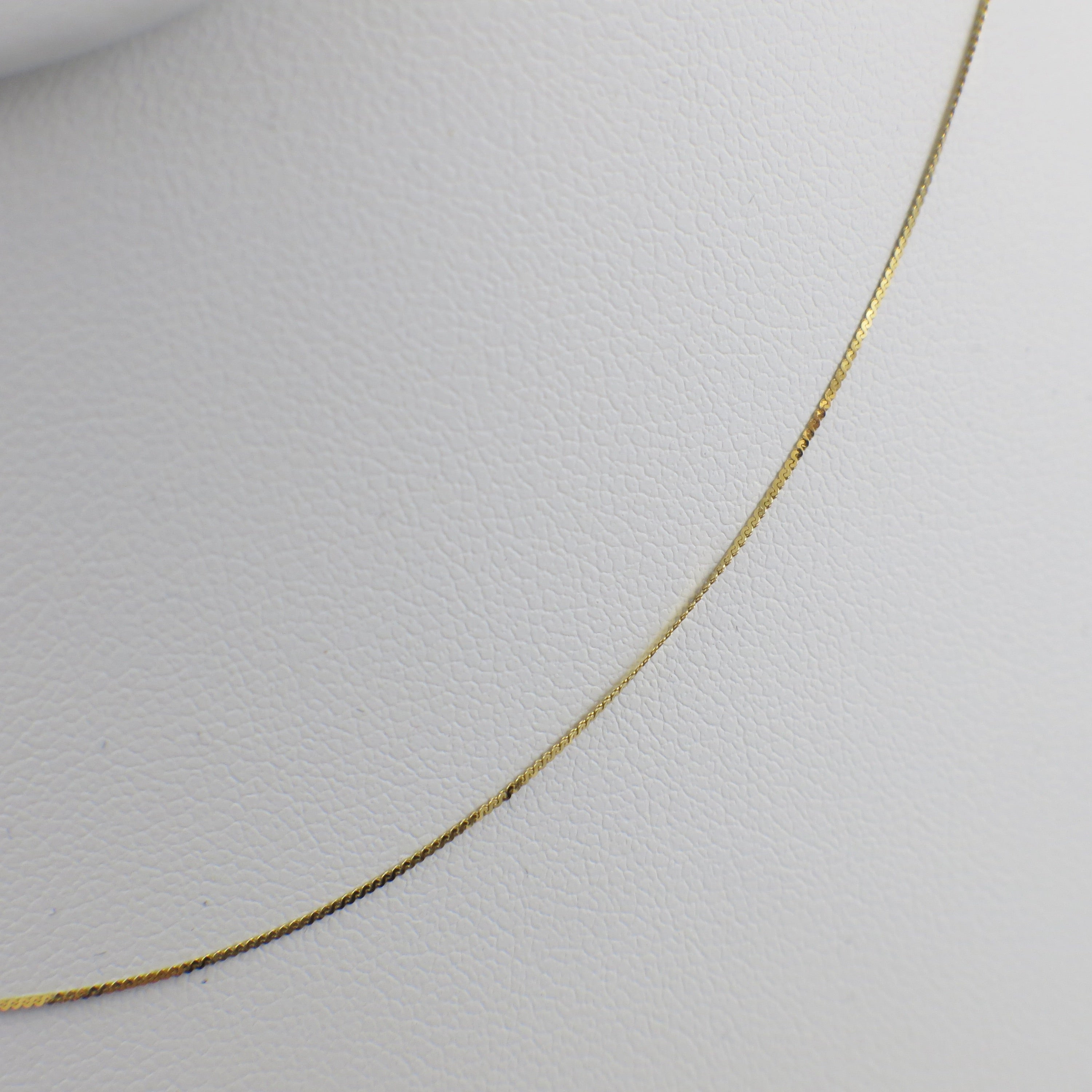 14K yellow gold serpentine chain necklace, 18 inches long, 0.5mm thickness, from Black Market LLC.