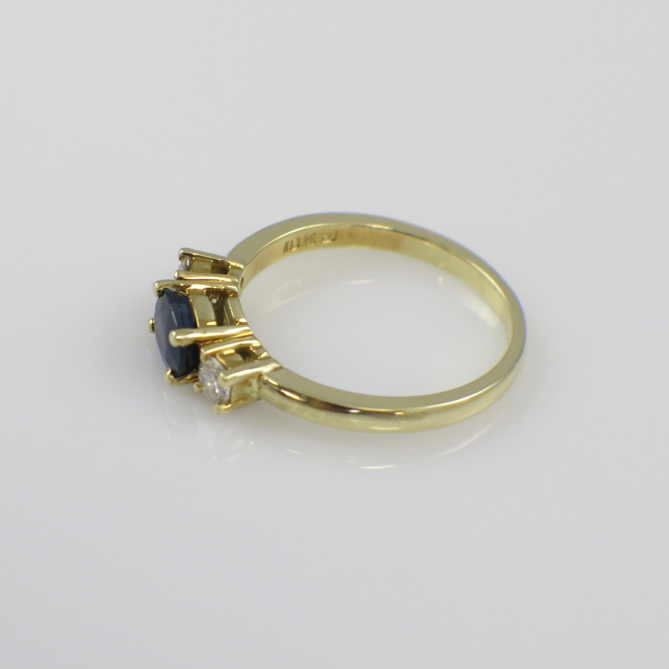 Vintage 18K gold East West sapphire diamond three stone ring with elegant design and intricate detailing.