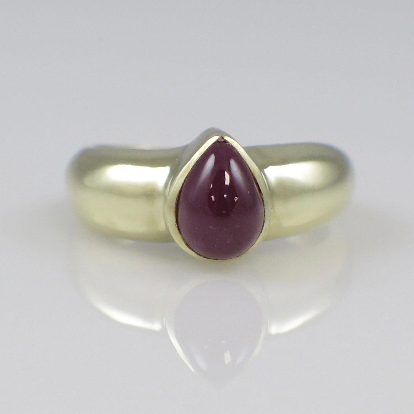Vintage 14K yellow gold ring featuring a pear-shaped cabochon ruby bezel setting, crafted by Black Market LLC.