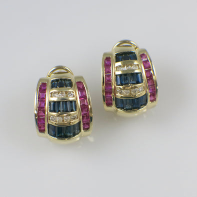 Pair of gold earrings with blue and red gemstones on a white background