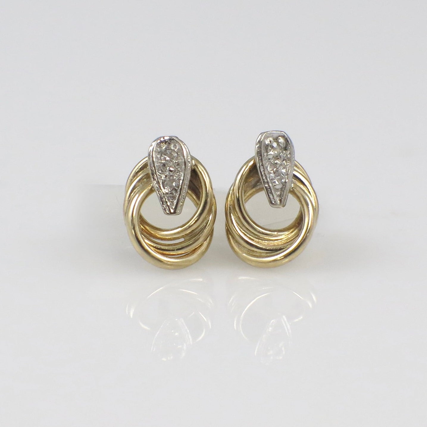 Vintage 14K two-tone gold diamond interlocking stud earrings with intricate design by Black Market LLC.