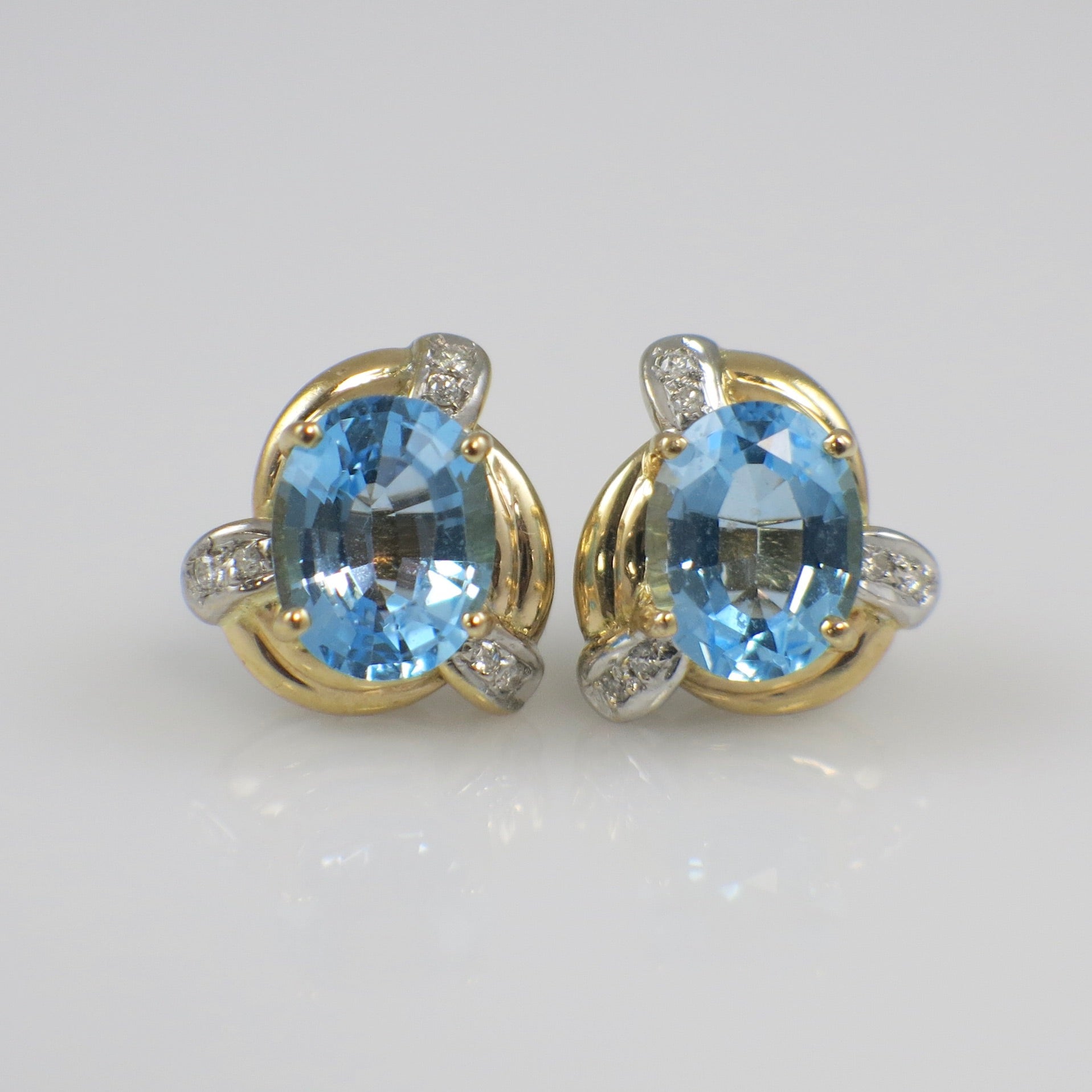 Pair of gold earrings with blue gemstones on a white background