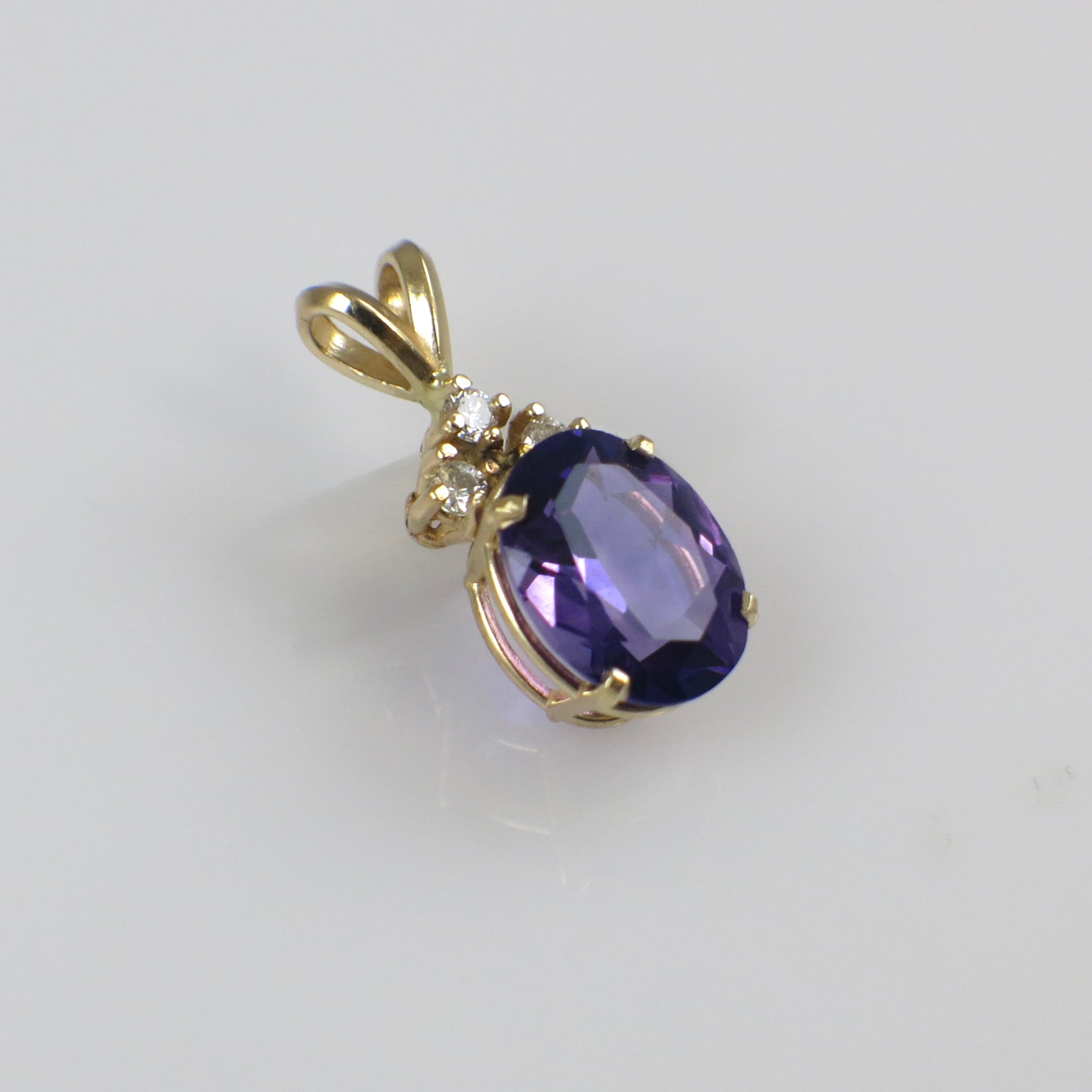 Vintage 14K yellow gold amethyst and diamond pendant necklace with intricate design and sparkling gemstones.