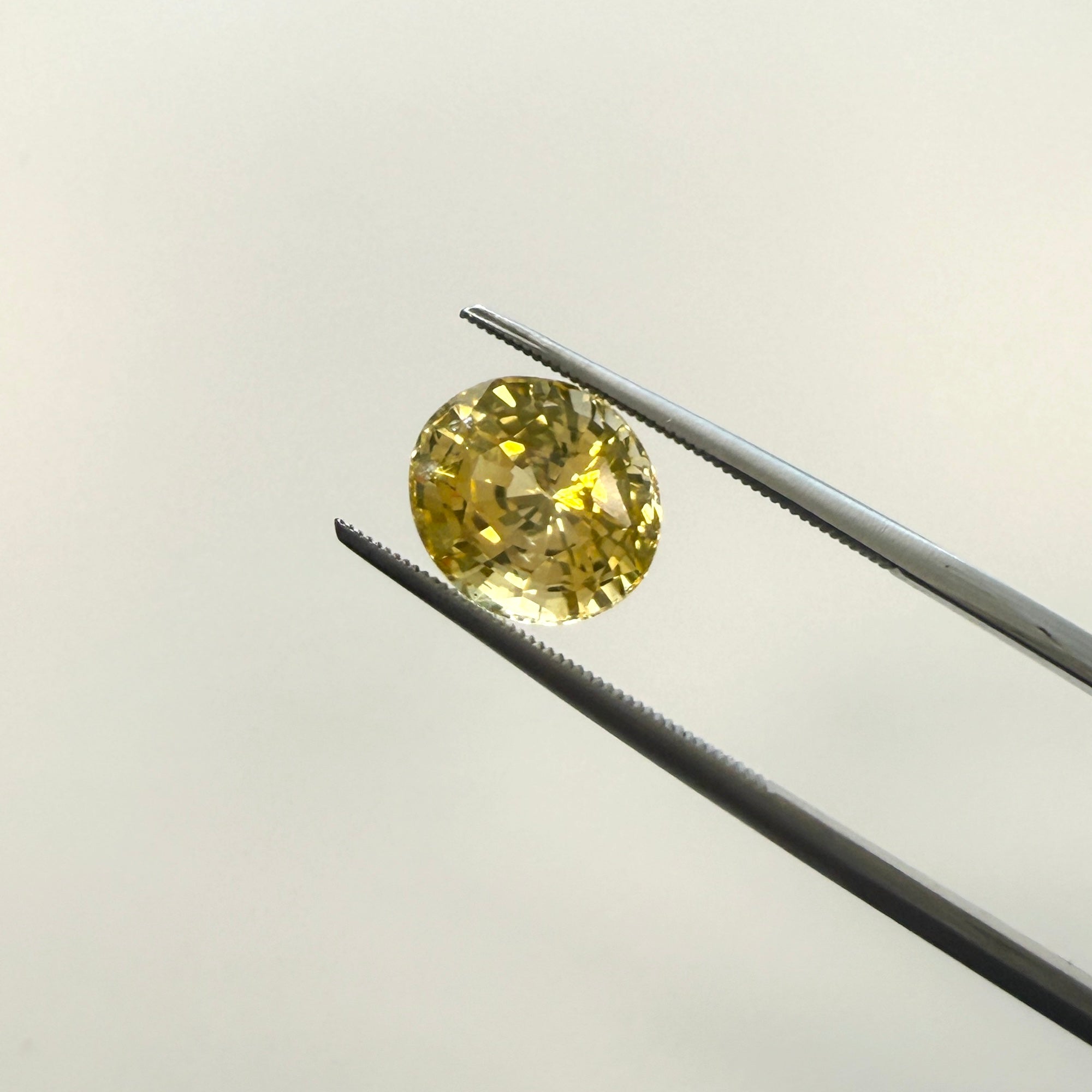 Oval GIA-certified yellow sapphire gemstone, 4.10ct, natural and heated, measuring 9.77x8.56mm, from Black Market LLC.