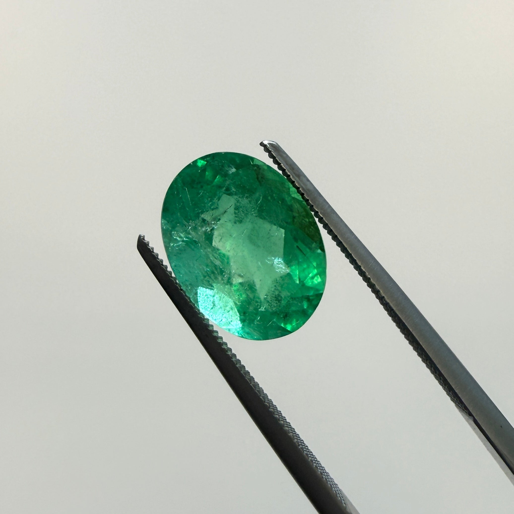GIA Certified 2.45ct oval green emerald beryl gemstone with minor enhancement, measuring 10.54 x 7.94mm, from Black Market LLC.