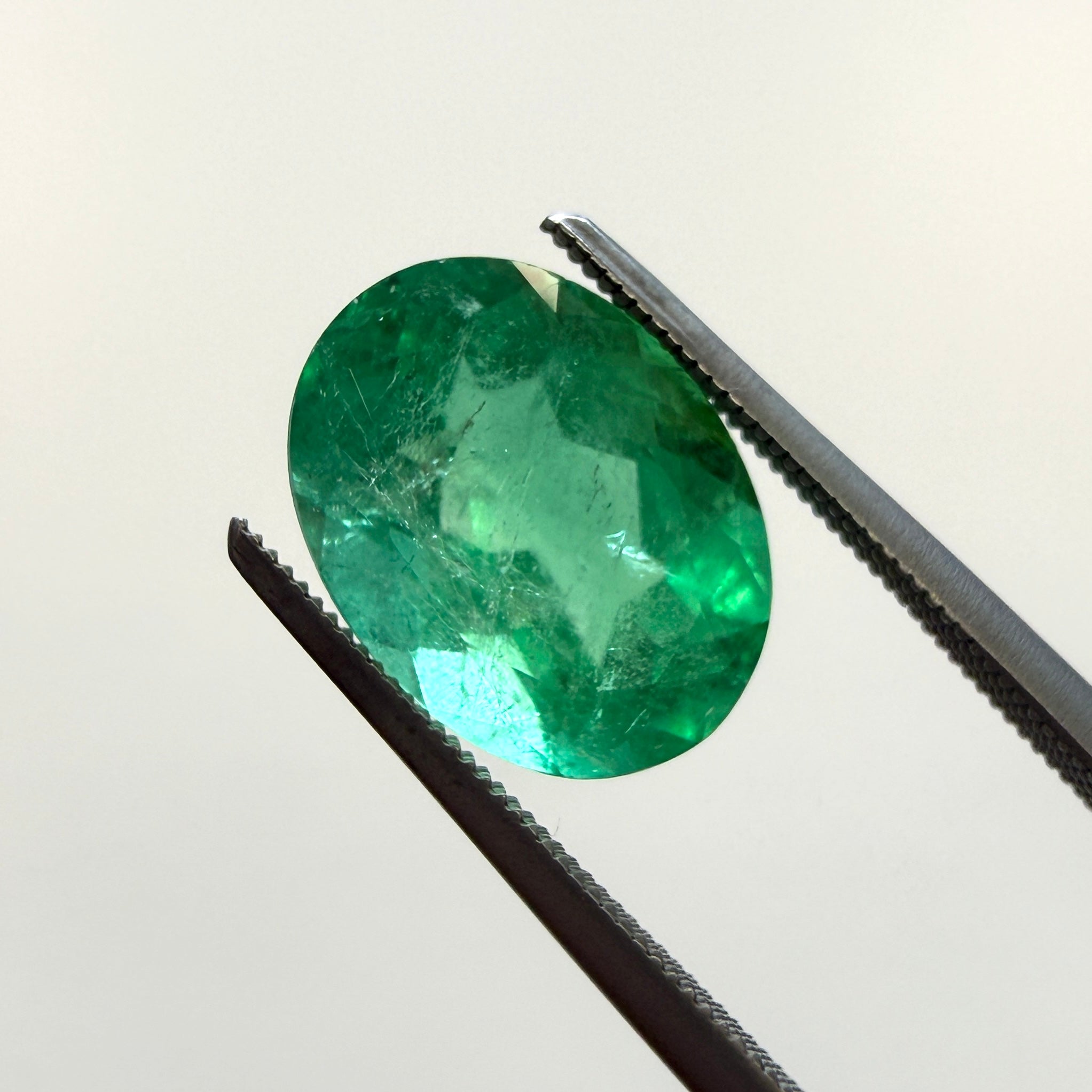 GIA Certified 2.45ct oval green beryl gemstone, Black Market LLC, with minor F1 enhancement, measuring 10.54 x 7.94mm