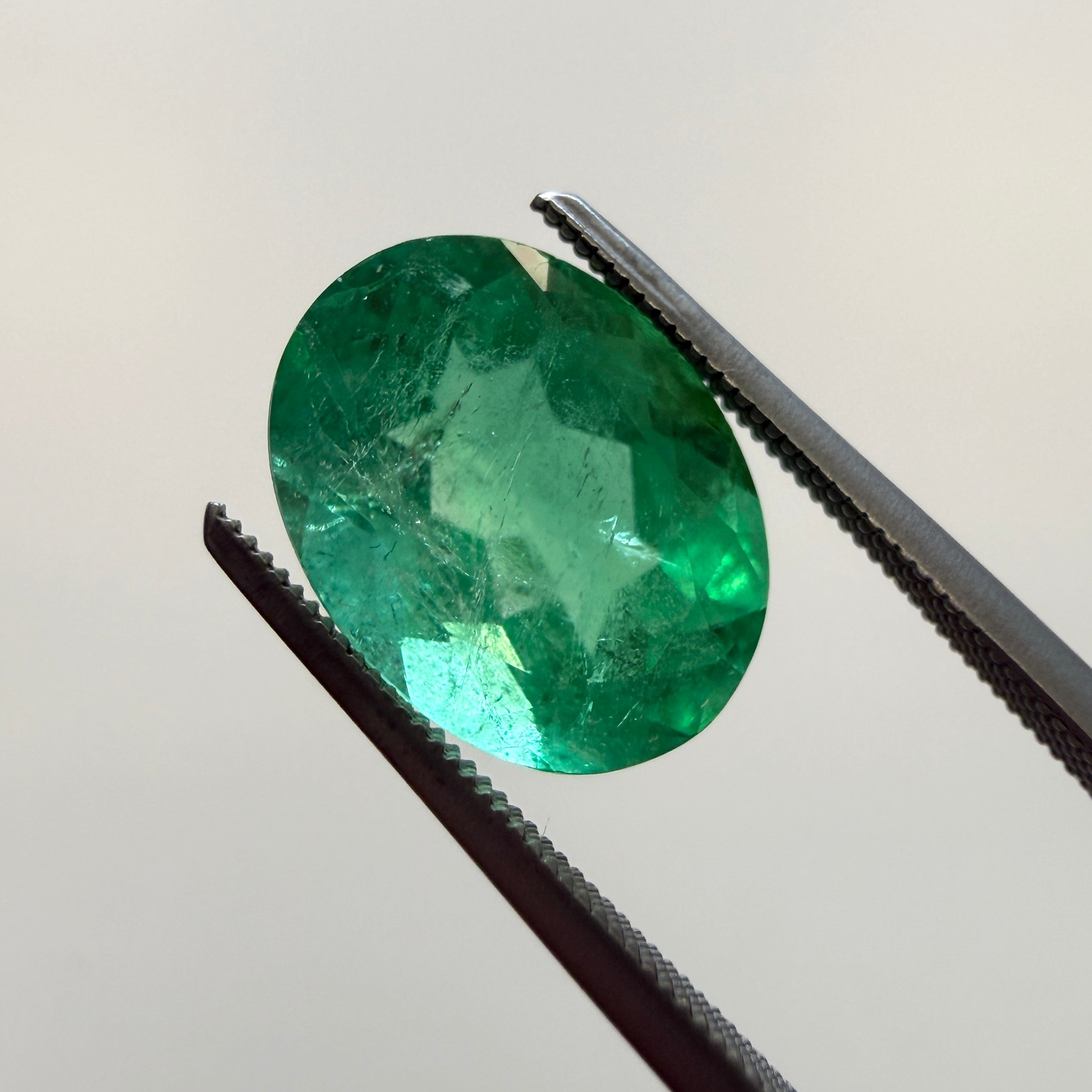 GIA Certified 2.45ct oval green beryl gemstone with minor enhancement, measuring 10.54x7.94mm, from Black Market LLC.