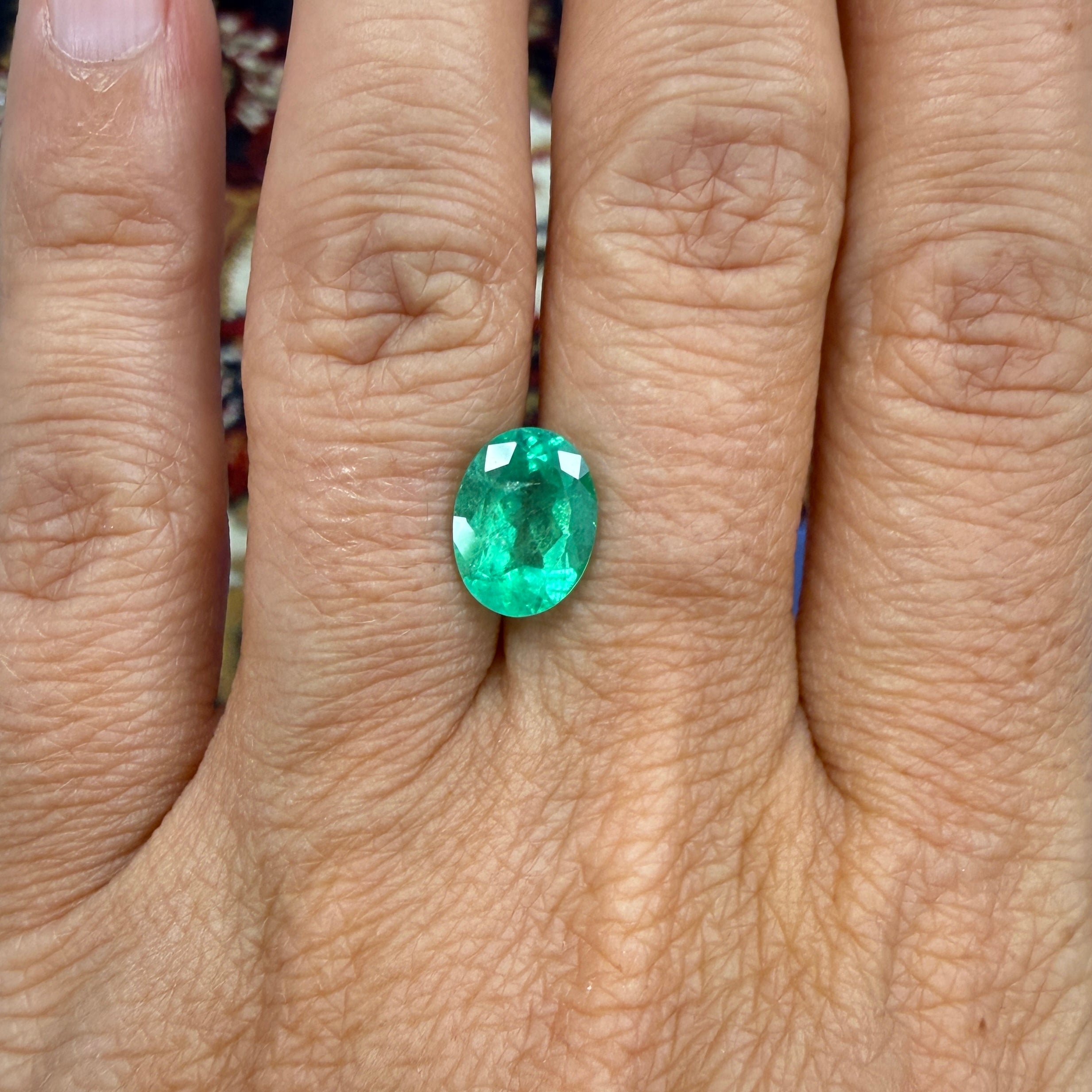 GIA Certified 2.45ct oval green emerald gemstone with minor enhancement, measuring 10.54 x 7.94mm, from Black Market LLC.