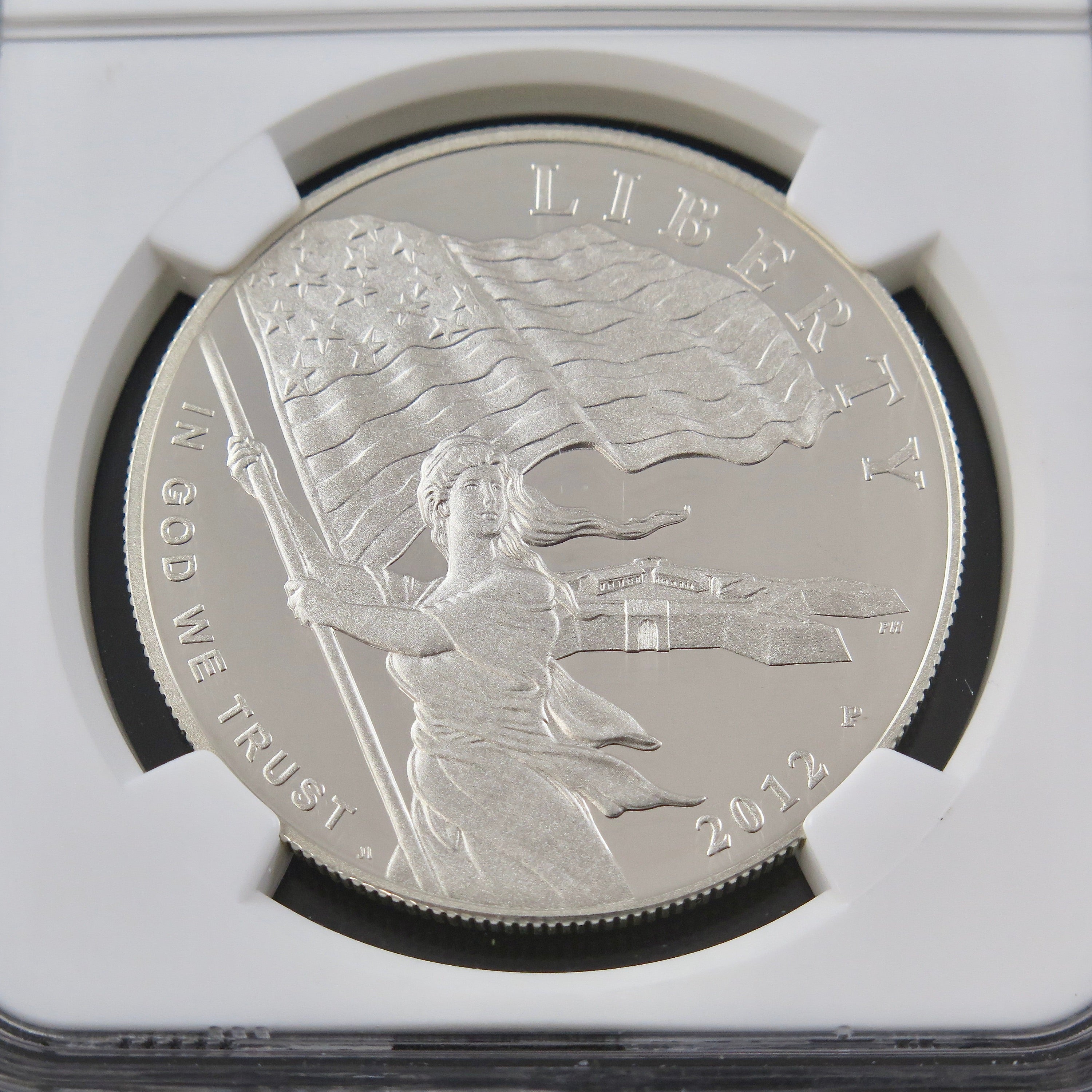 Close-up of the 2012 Star Spangled Banner Dollar commemorative coin in PF70 NGC ER holder, showcasing detailed design and engraving.