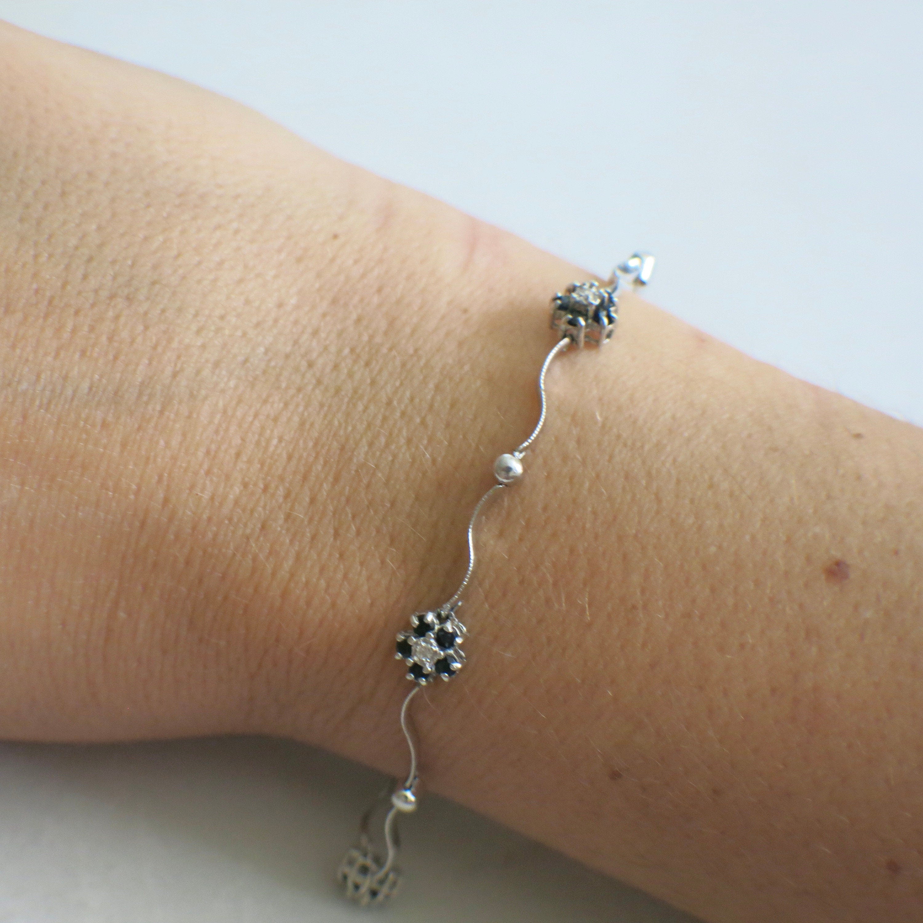 14K white gold sapphire and diamond flower bracelet featuring a delicate floral design, 7-inch length, by Black Market LLC.