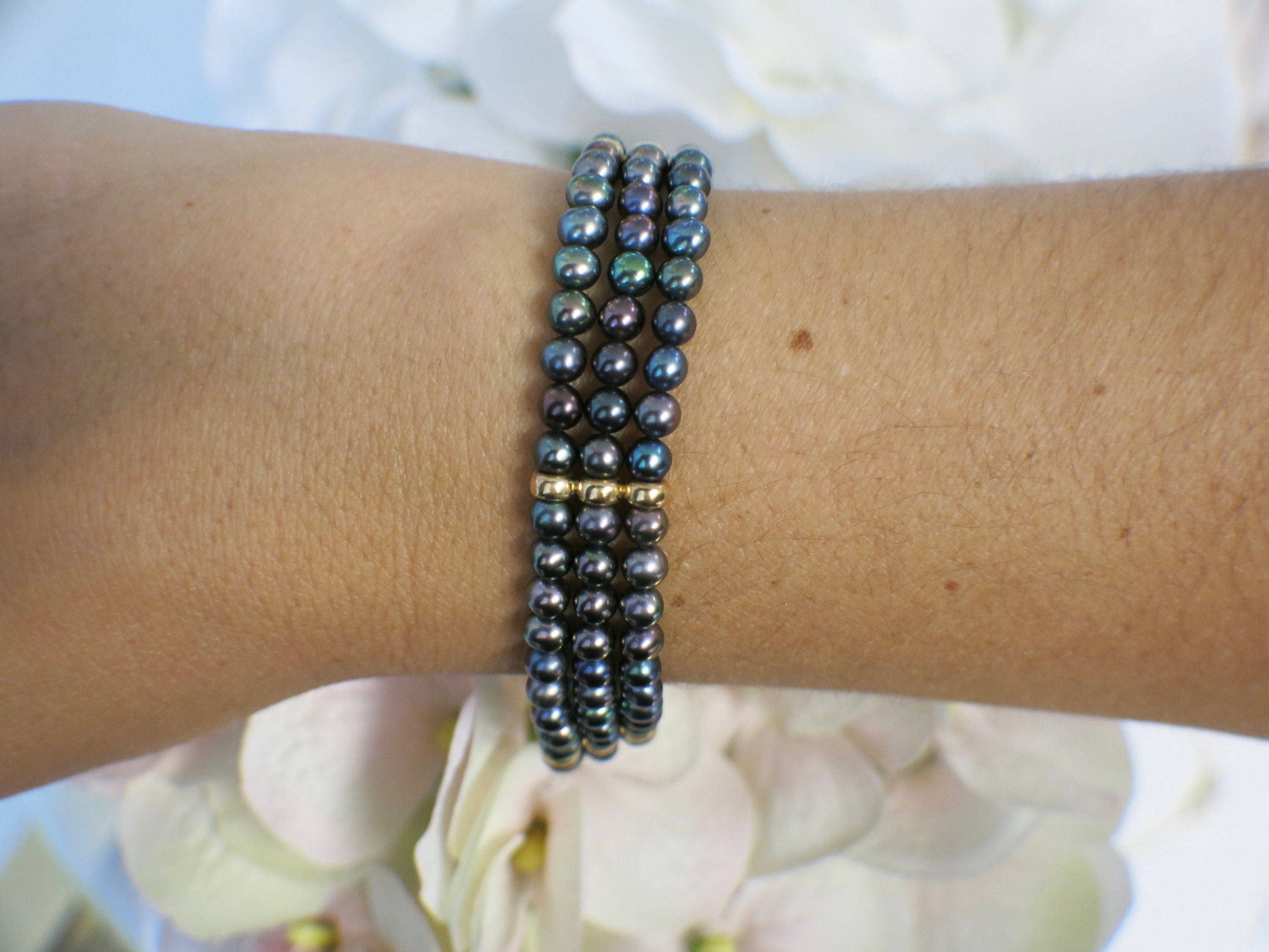 14K yellow gold three-strand Tahitian black pearl bracelet with vintage filigree clasp, elegant jewelry piece from Black Market LLC.