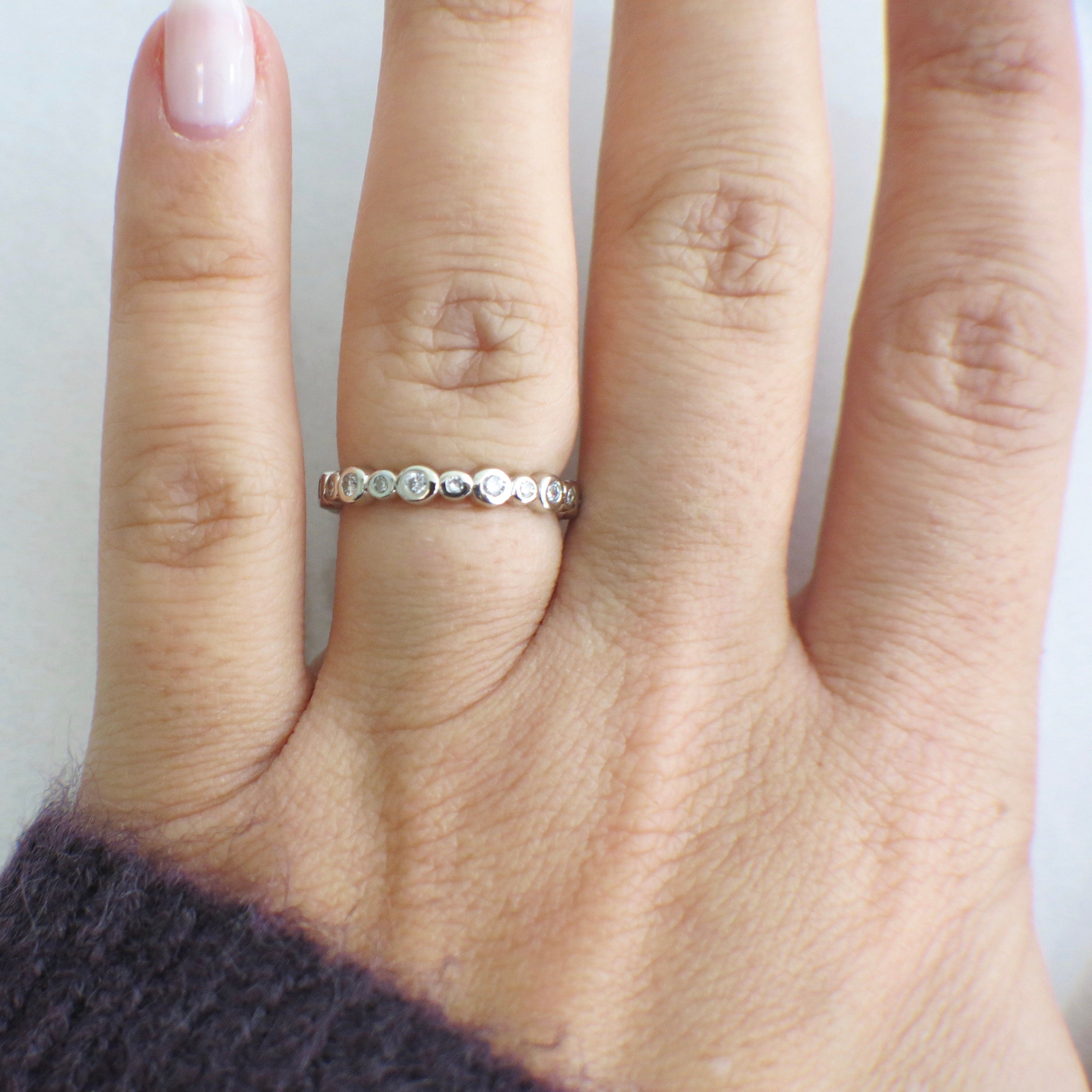 14K white gold diamond bezel eternity band ring with stackable design, featuring sparkling diamonds, size 5.5, by Black Market LLC.