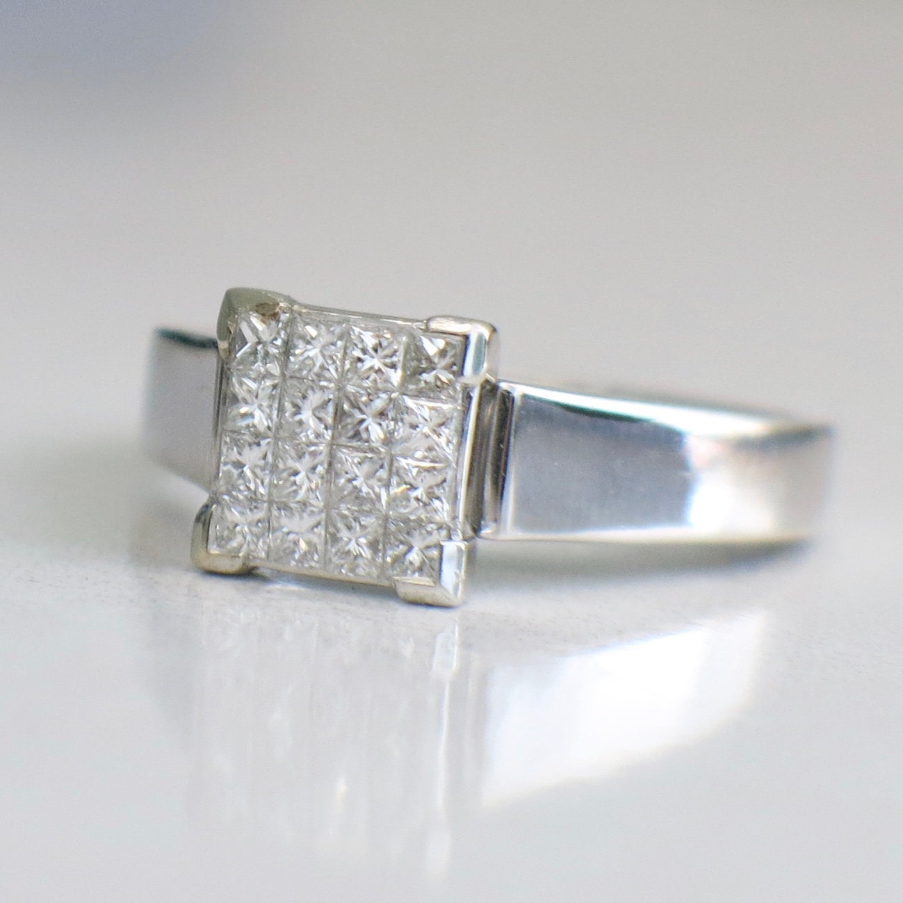 14K white gold diamond ring with a princess cut diamond cluster in an invisible setting, totaling 0.50 carats.
