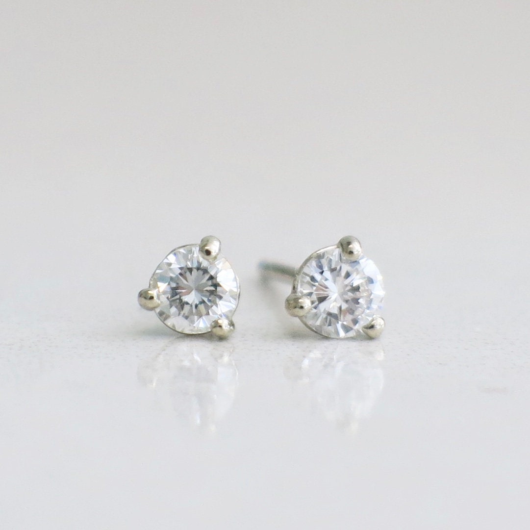 Diamond stud earrings with 0.29 CT diamonds in 14K white gold martini setting, SI1 E–F clarity from Black Market LLC.