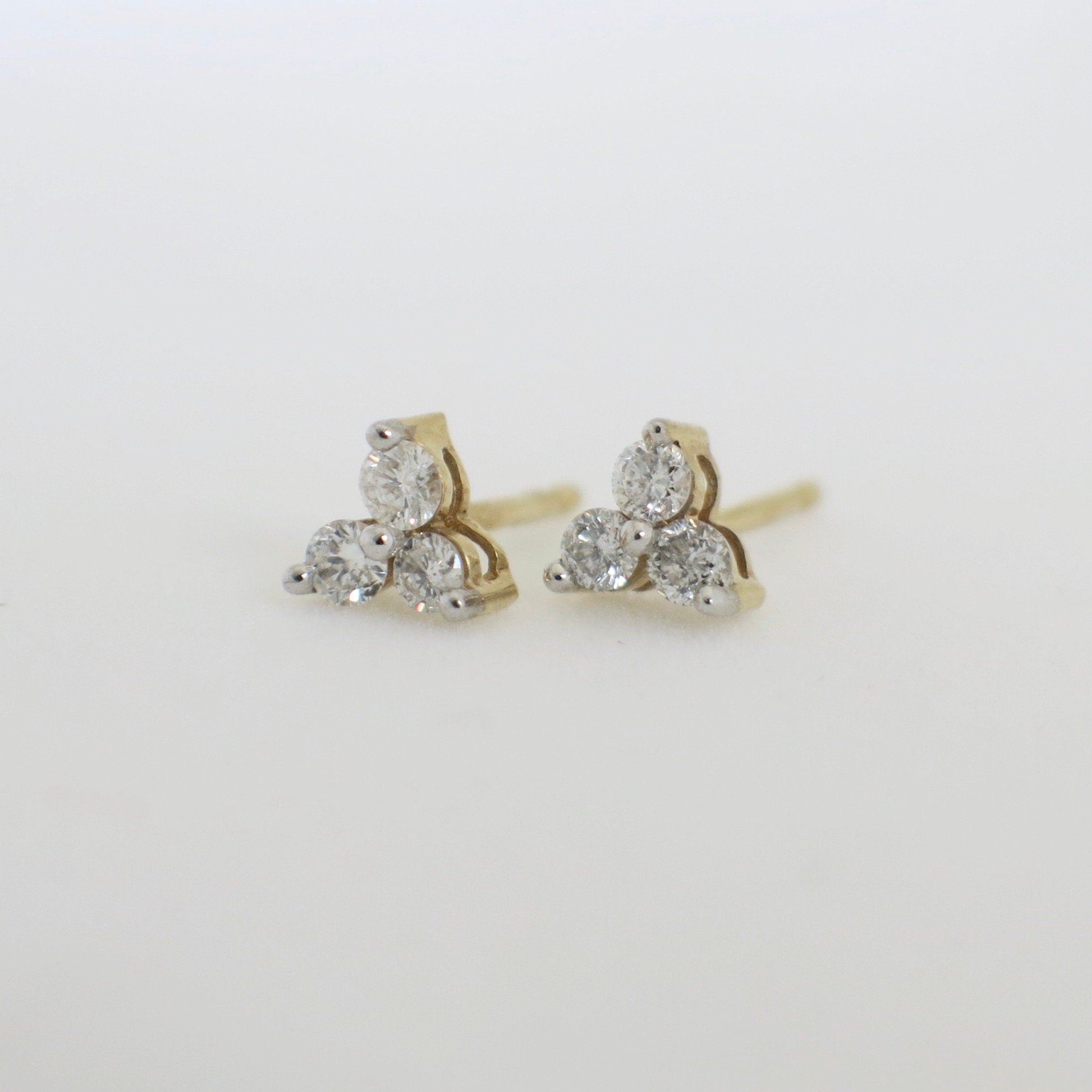 14K gold diamond stud earrings featuring a three-stone cluster design with sparkling diamonds from Black Market LLC.