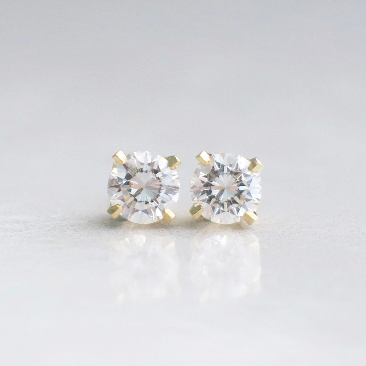 Diamond stud earrings with 0.64 CTW round brilliant diamonds set in 14K yellow gold with threaded backs.