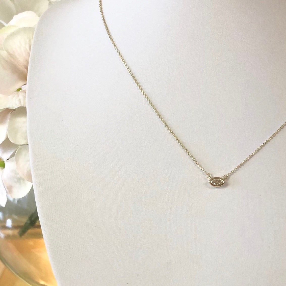 14K gold marquise diamond bezel necklace with east-west solitaire pendant, showcasing elegant jewelry design.