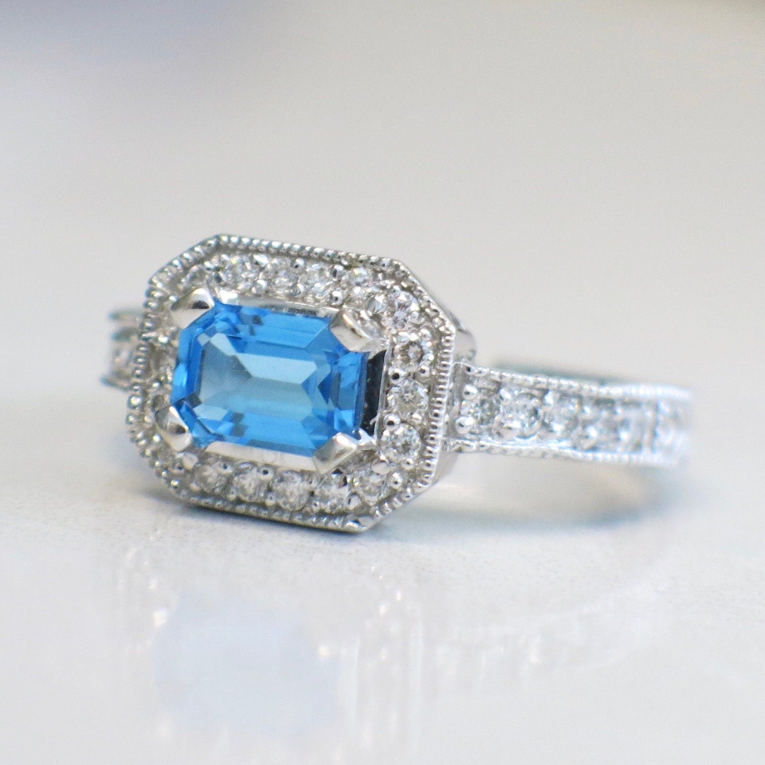 14K white gold Swiss Blue Topaz and diamond ring with east-west halo design, size 8.5, by Black Market LLC.