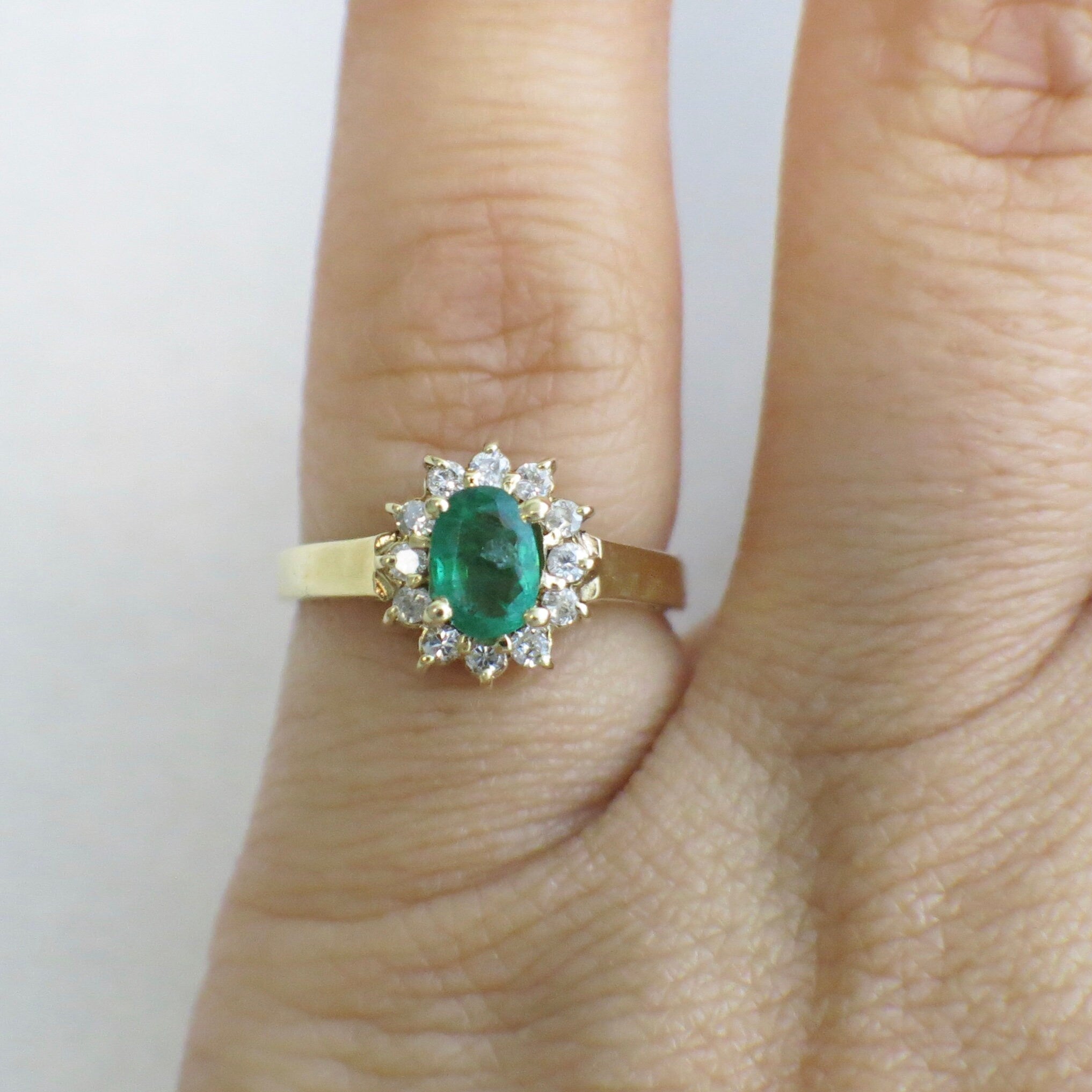 14K yellow gold emerald and diamond halo ring featuring an oval May birthstone, size 3.75, by Black Market LLC.