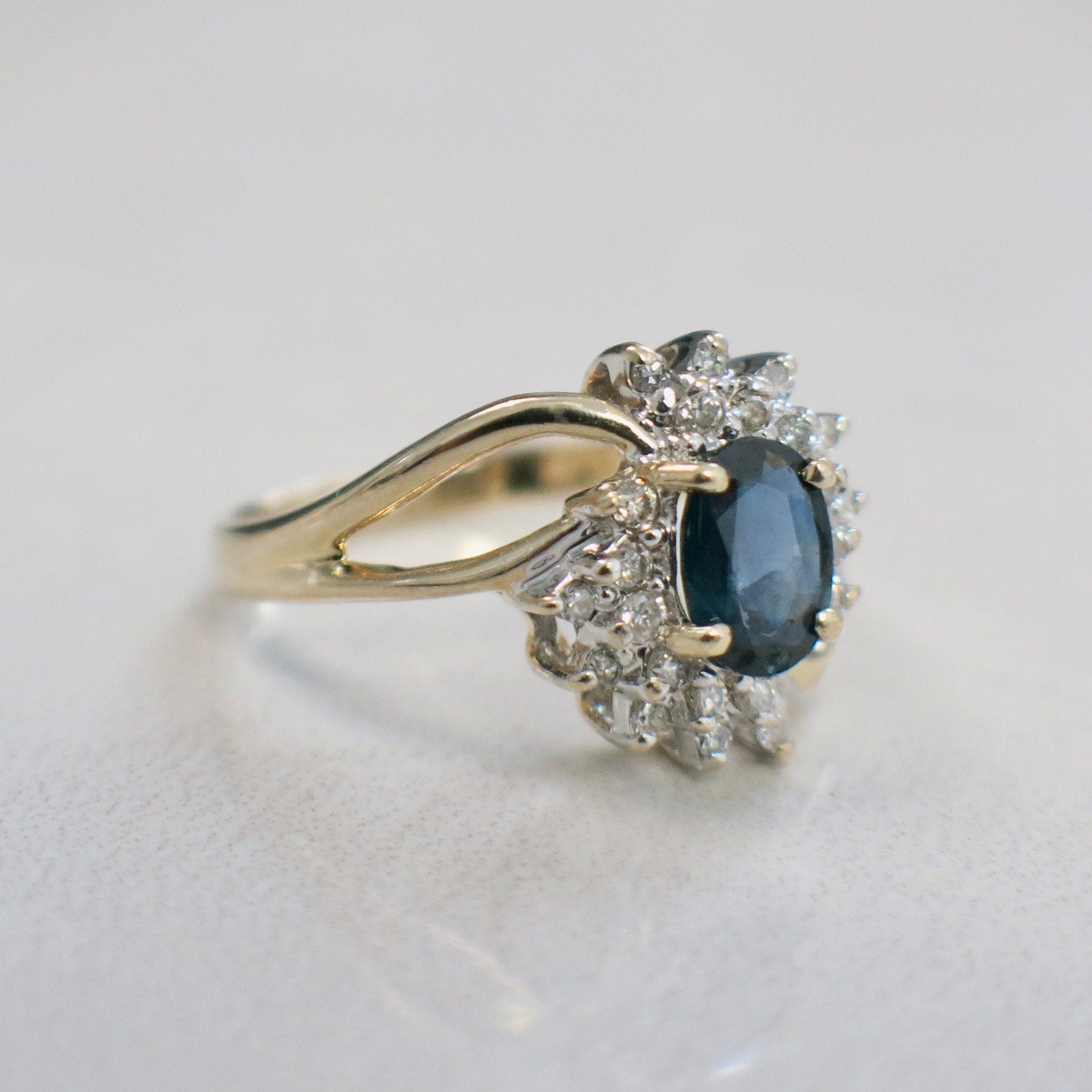 14K yellow gold oval sapphire and diamond halo ring with split shank, size 6.5, featuring elegant jewelry design.