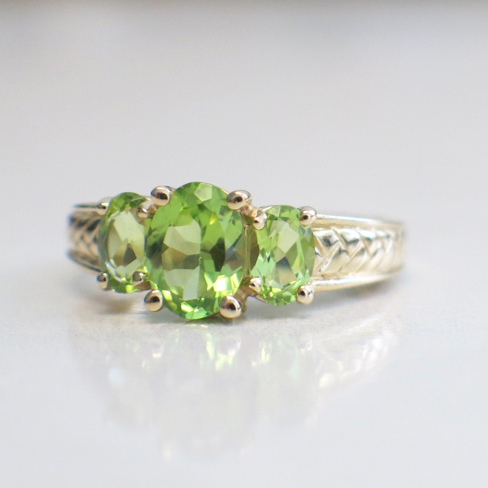 14K yellow gold Peridot three-stone ring featuring oval-cut August birthstones in size 7, crafted by Black Market LLC.