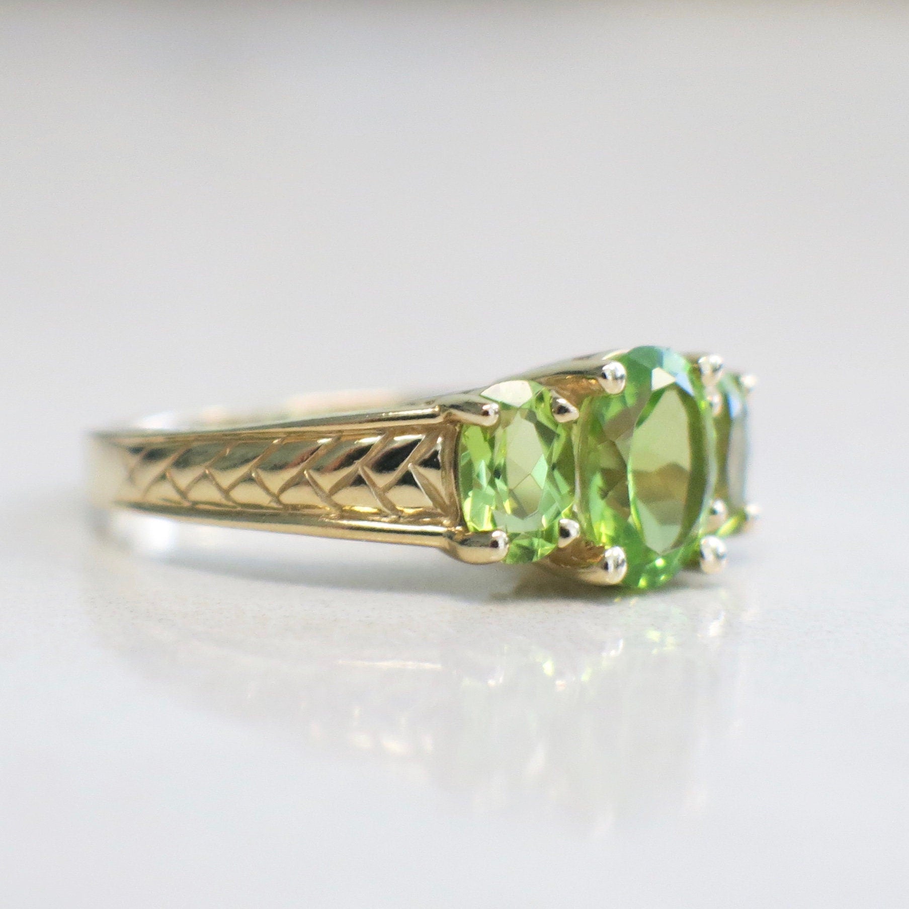 14K yellow gold peridot three-stone ring with oval-cut August birthstones, size 7, by Black Market LLC.