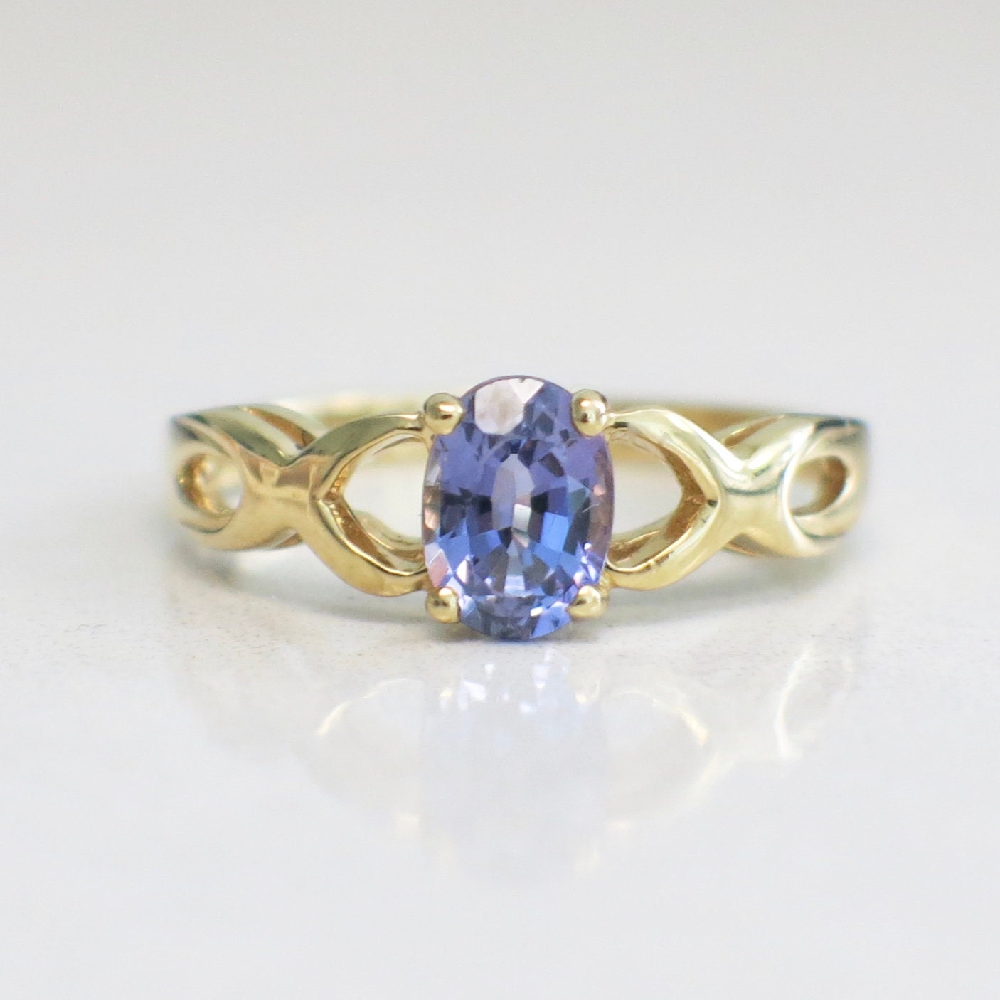 14K yellow gold Tanzanite oval ring with infinity twist band, December birthstone, size 8.5, by Black Market LLC.