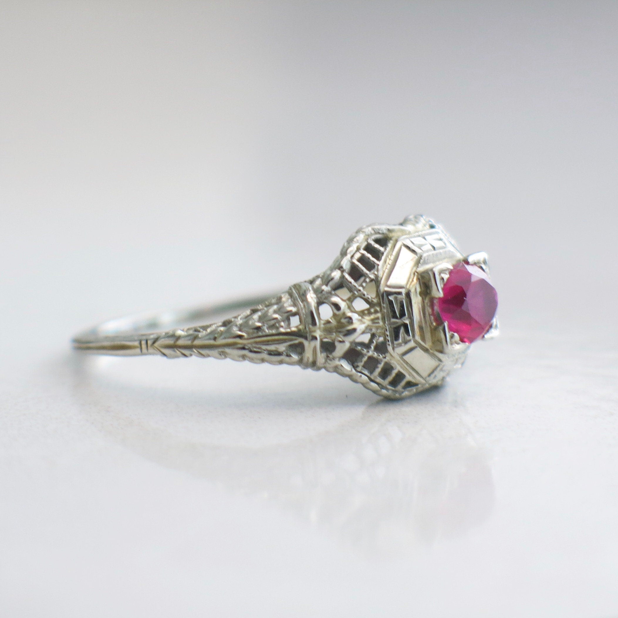 Art Deco filigree ring in 18K white gold with pink sapphire, size 7.75, featuring intricate design and elegant craftsmanship.