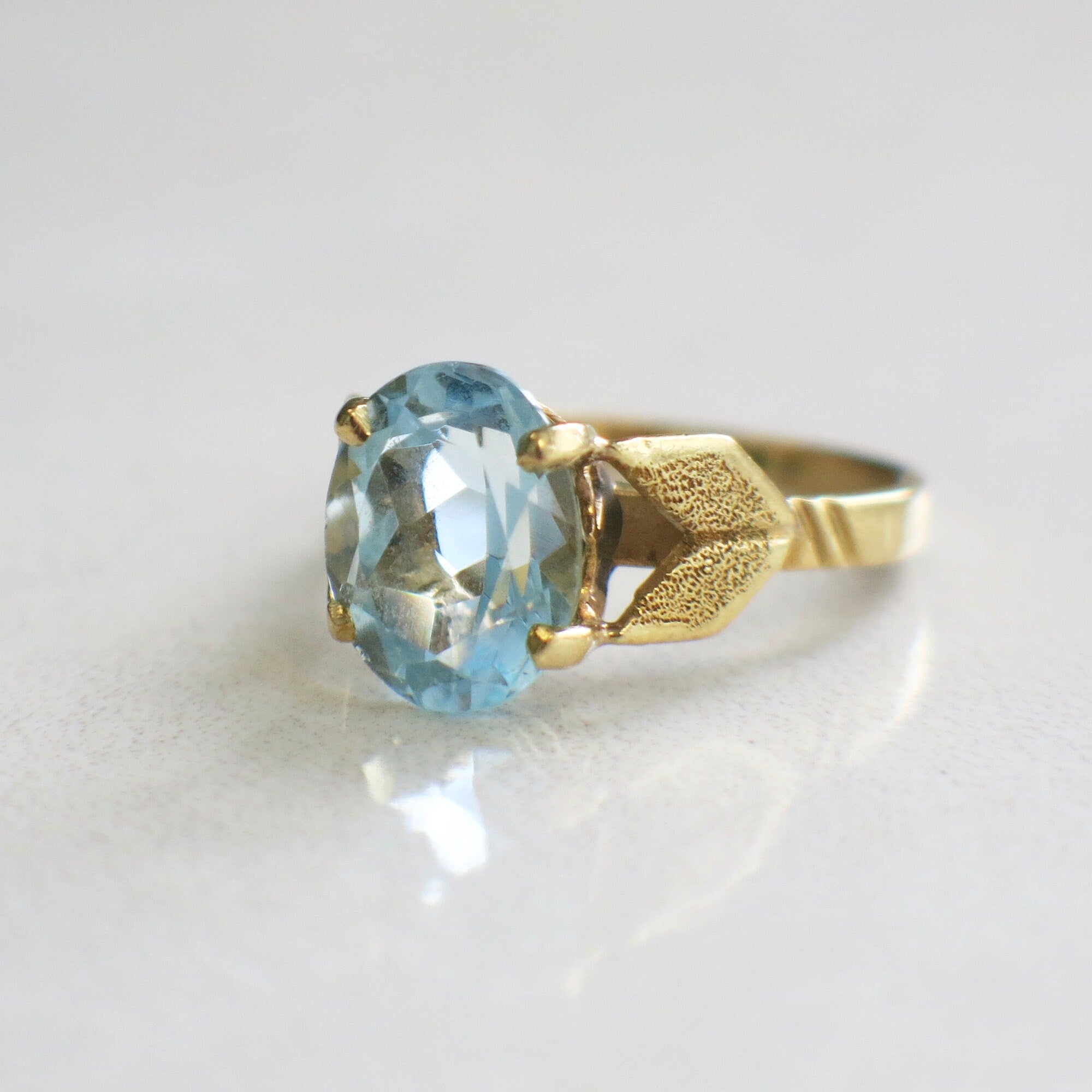 Large aquamarine oval solitaire ring in 18K yellow gold with vintage design, size 4.75, by Black Market LLC.