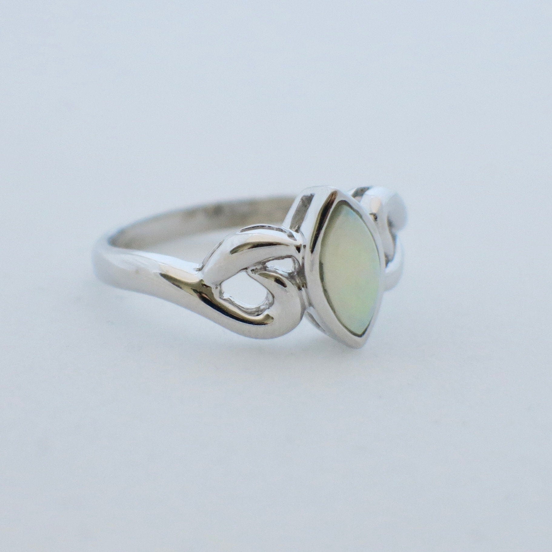 Marquise opal ring in 14K white gold with bezel-set cabochon, size 5.5, featuring elegant jewelry design.