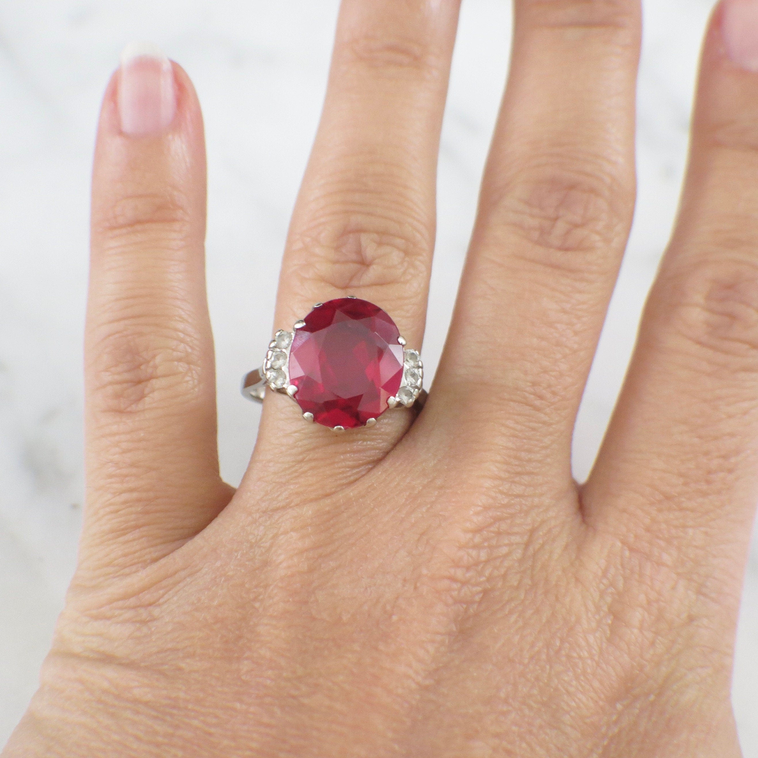 Vintage 10K white gold cocktail ring with oval lab ruby and diamonds, size 7.25, by Black Market LLC.