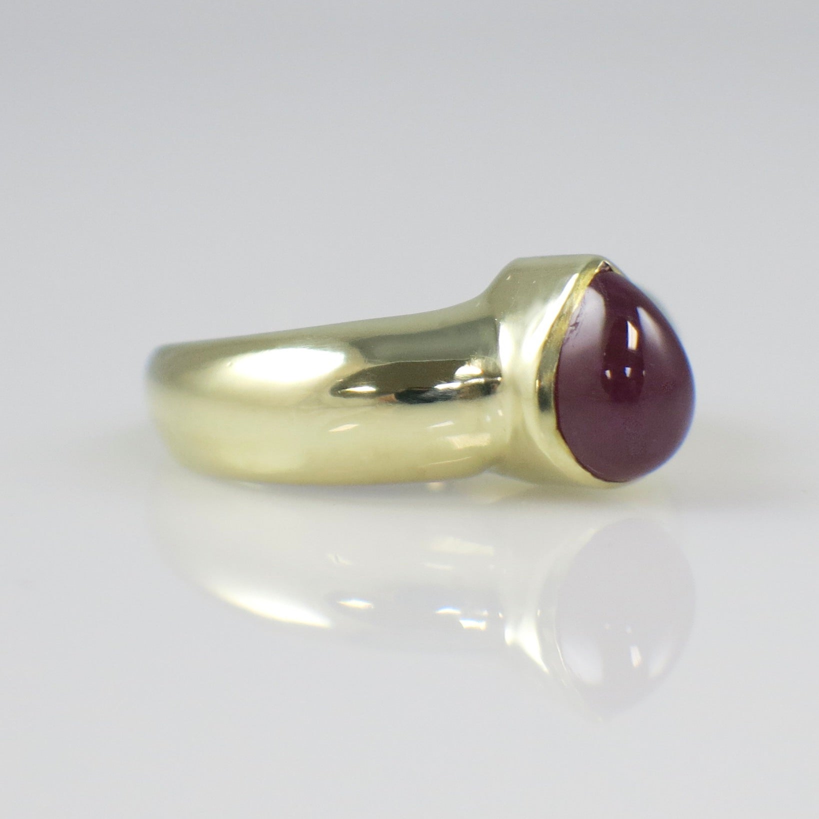 Vintage 14K yellow gold ring with a pear-shaped cabochon ruby bezel-set, bold gemstone jewelry by Black Market LLC.