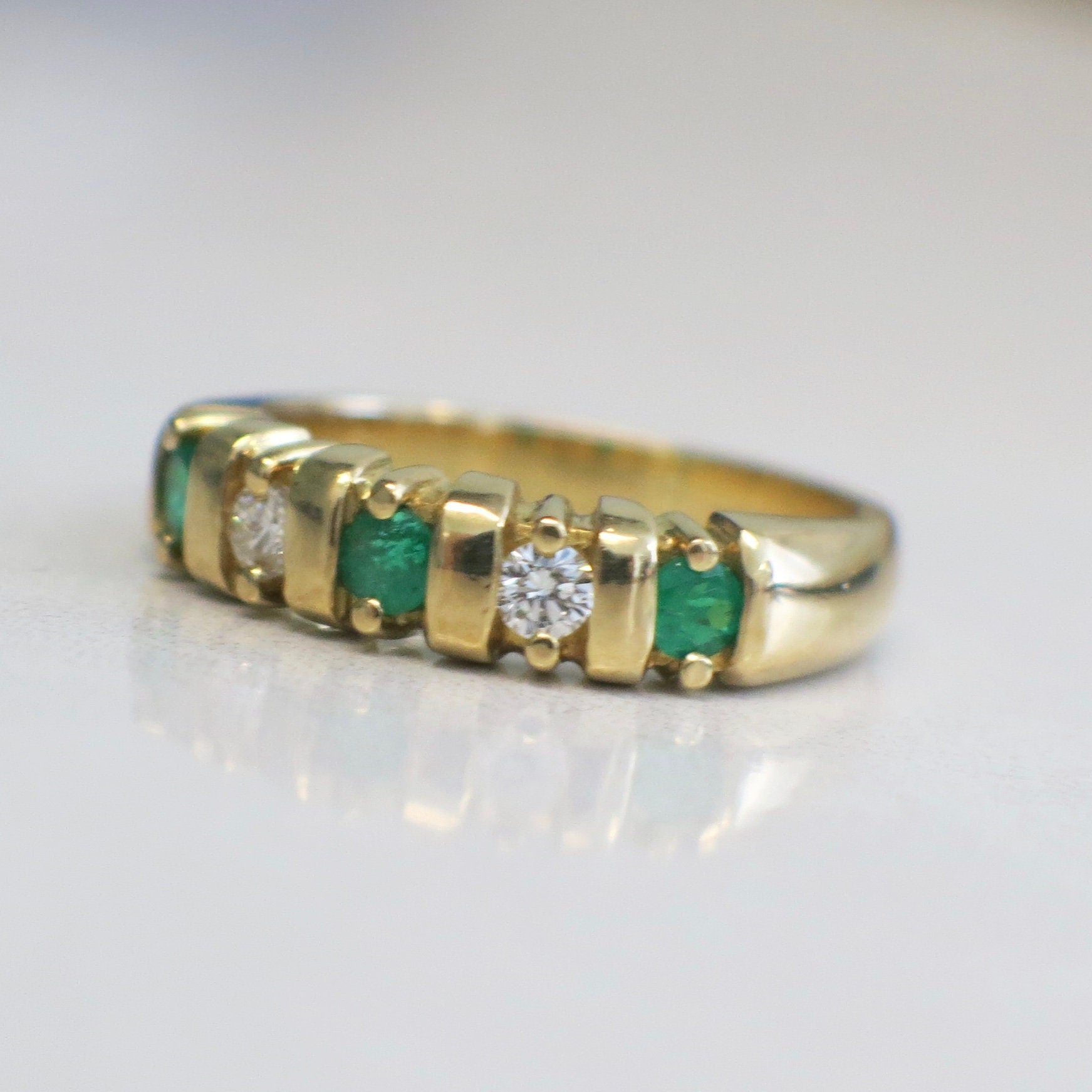 Vintage 18K yellow gold emerald and diamond five-stone anniversary ring in size 7 with intricate design.
