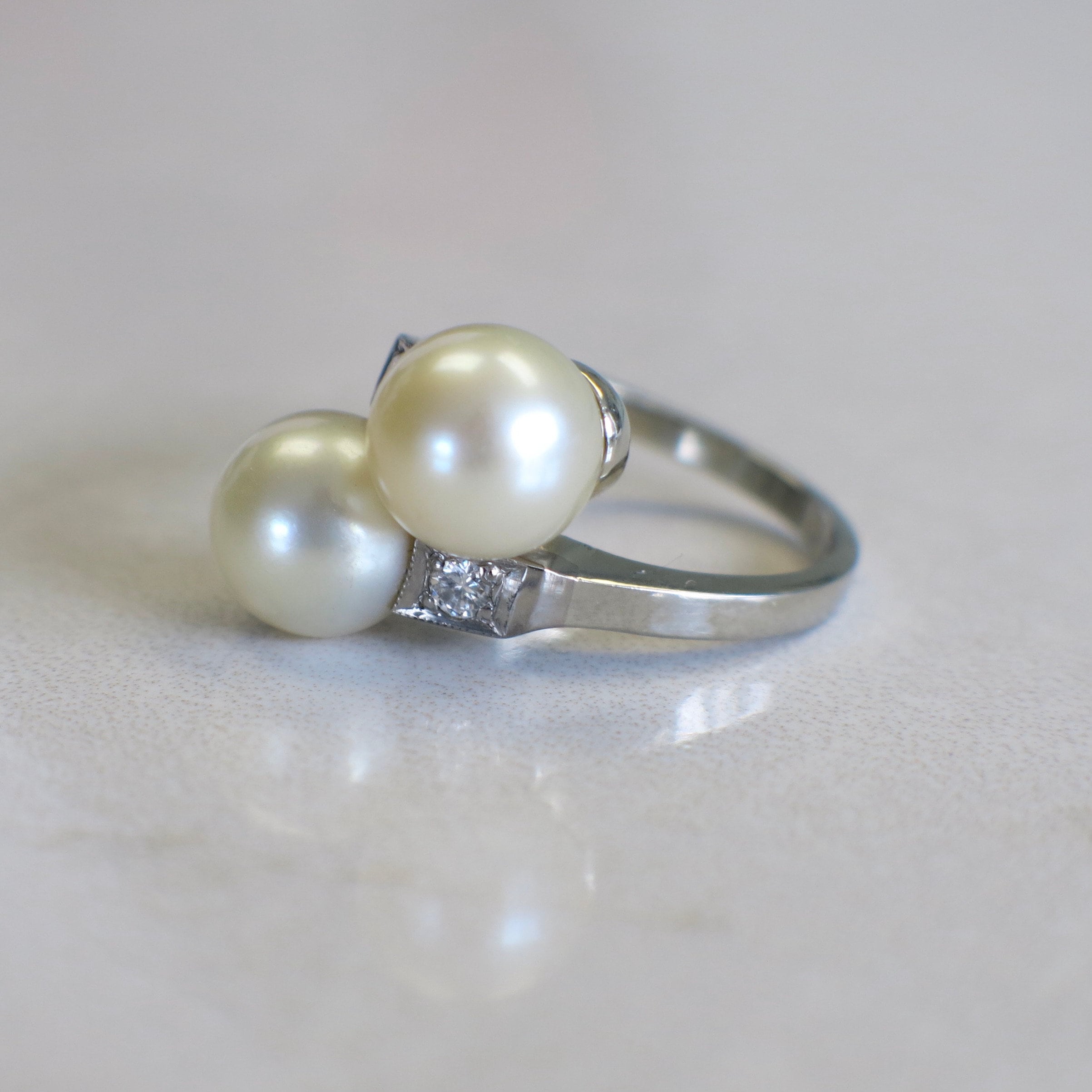 Vintage pearl and diamond ring in 14K white gold with a two-stone milgrain design, featuring elegant and intricate craftsmanship.