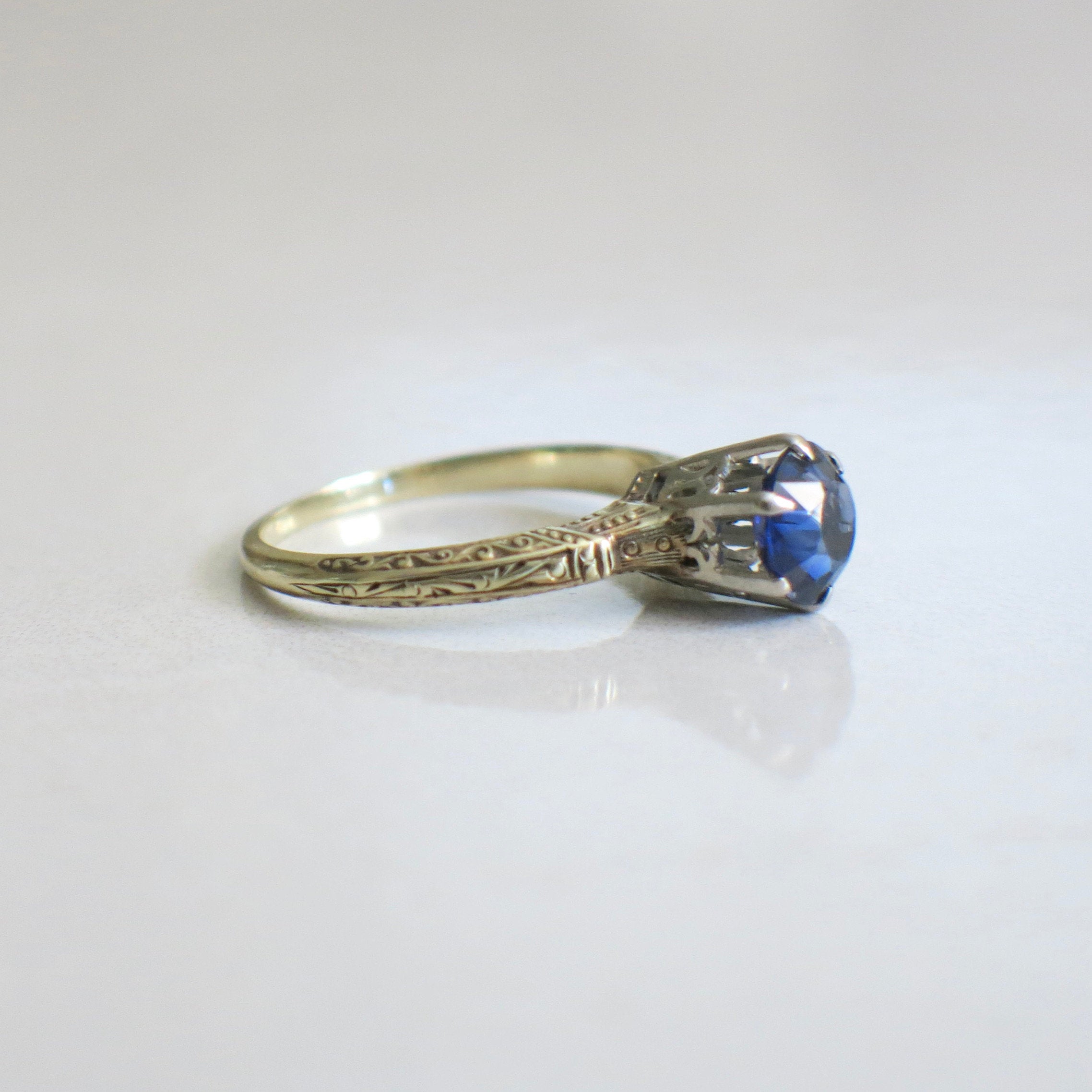 Vintage sapphire blue glass ring with 14K two-tone gold filigree crown setting, size 6.75, by Black Market LLC.