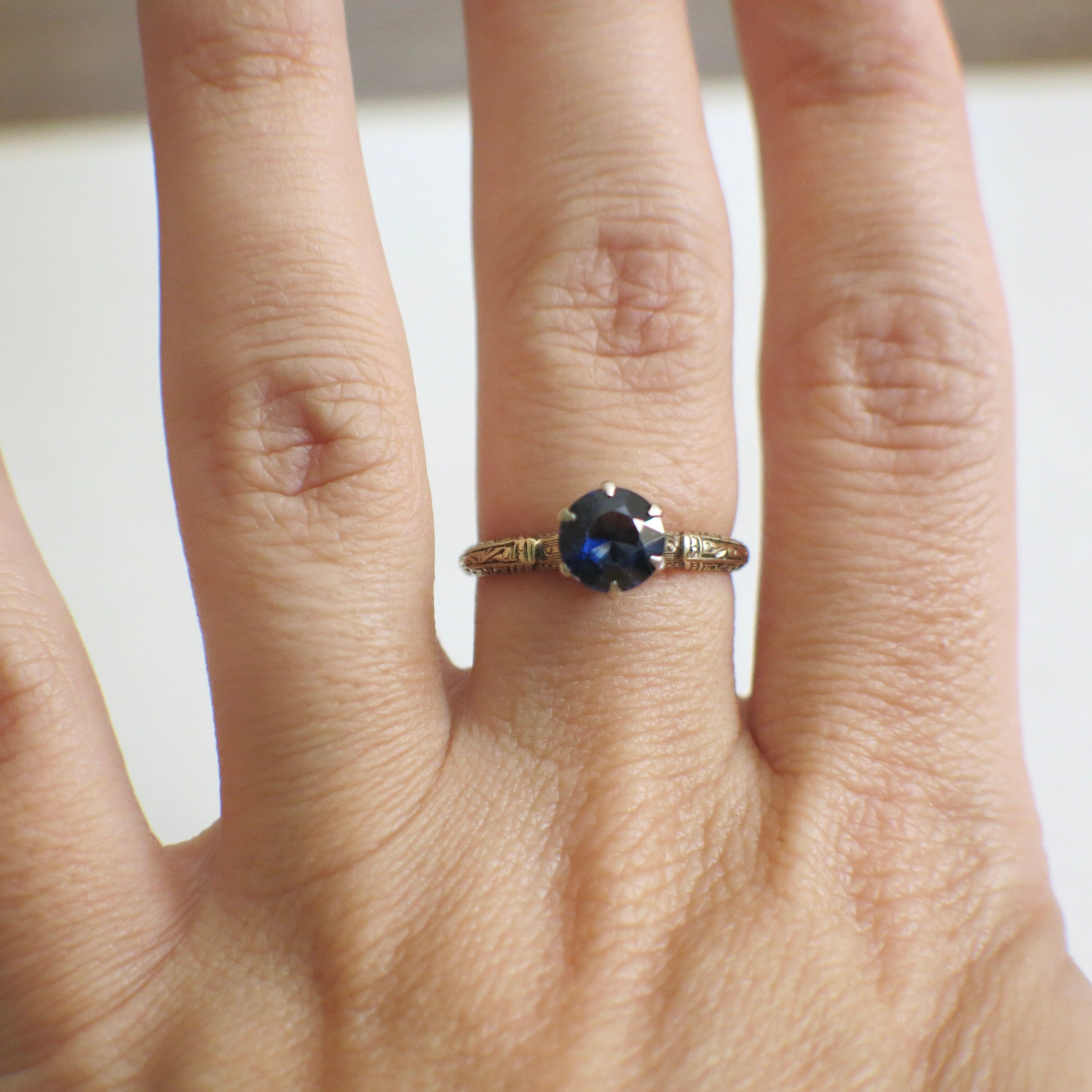 Vintage sapphire blue glass ring with 14K two-tone gold filigree crown setting, size 6.75, from Black Market LLC.