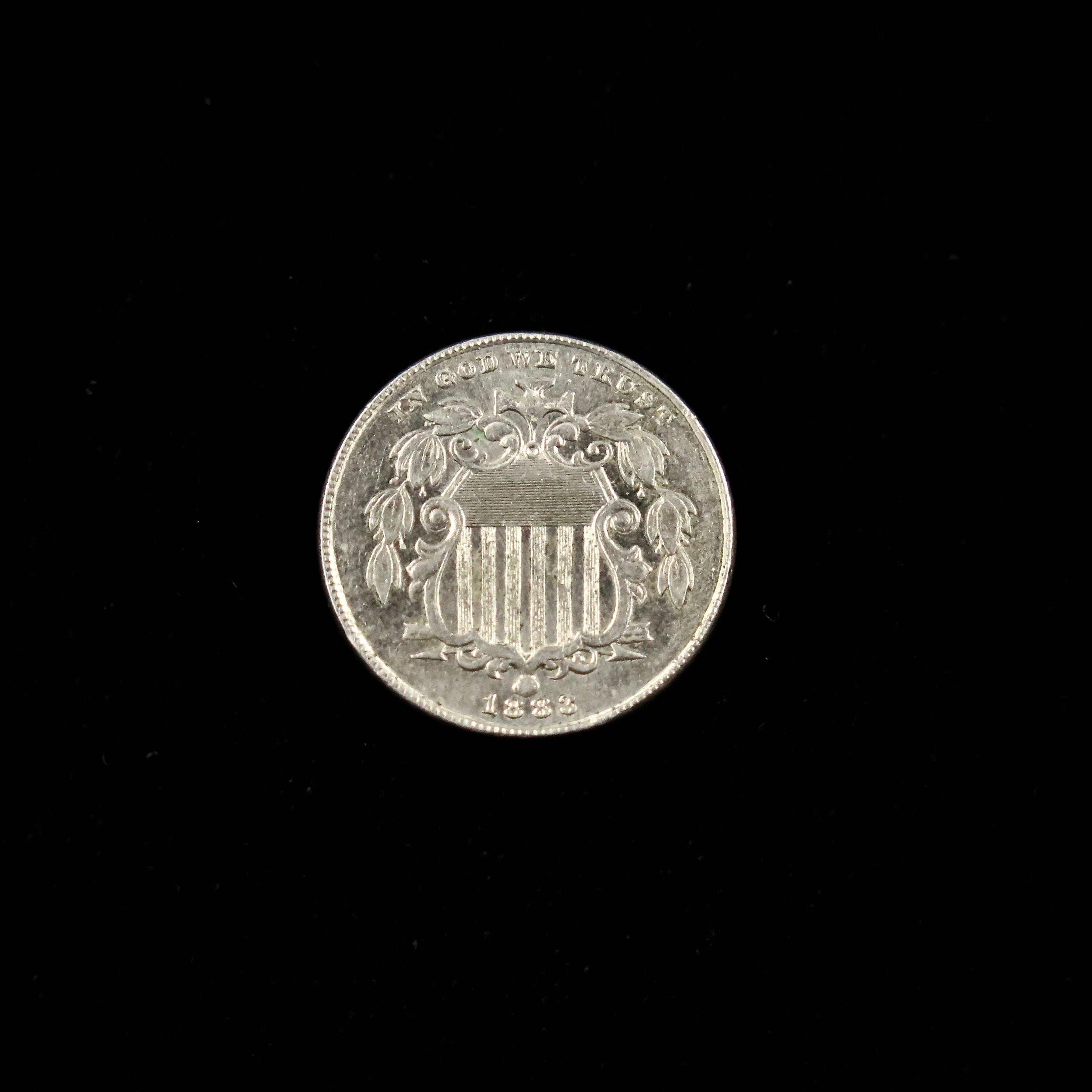 1883 Shield Nickel in mint state, raw U.S. five-cent coin, final year, featuring detailed shield design and historical coin features.