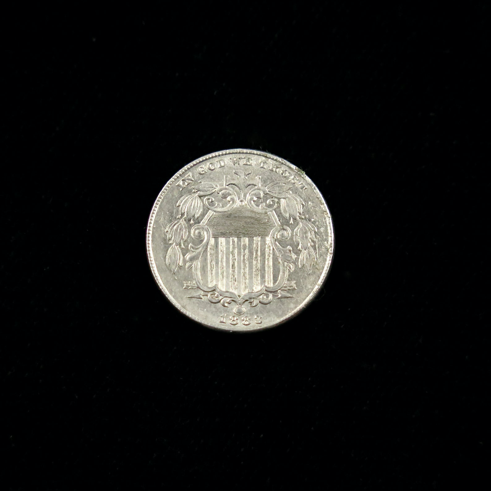 Mint state 1883 Shield Nickel five-cent coin from Black Market LLC, showing detailed design and raw silver surface.